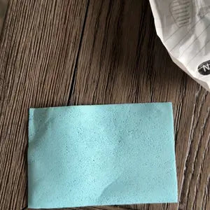 Single blue floor-cleaning tablet on a wood surface