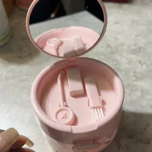 Open pink case showing the built-in mirror, brush, and removable tray